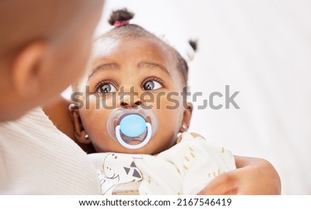 Is it time for an afternoon nap already. Shot of an adorable baby girl sucking a dummy while being held by her mother at home. Stockfoto © 