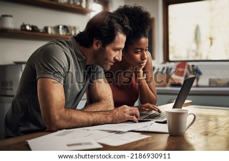 Couple with a laptop doing finance paper work, paying debt insurance loans or online ebanking together at home. Two serious people planning and looking at financial document, bills rate for mortgage Foto stock © 