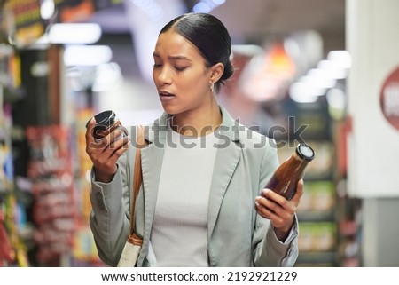 Shopping, retail and customer in a store or supermarket, reading product labels of choice to decide or compare sauce bottles. Consumerism, spending and shopping for food, groceries and a sale offer Сток-фото © 