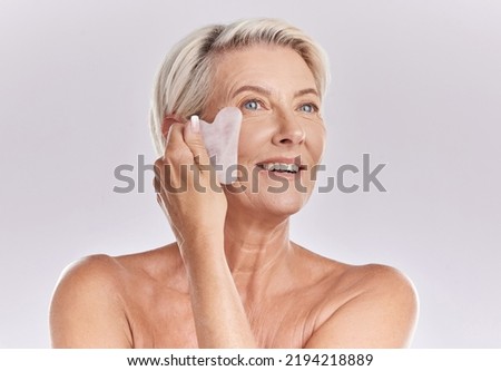 Woman doing skincare for wellness, beauty product for facial health and cosmetic on face for healthy skin on mockup studio background. Person with smile doing gua sha massage for body with mock up Foto stock © 