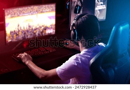 Similar – Image, Stock Photo Man playing video game at home. Gamer playing online in dark room lit by neon lights. Competition and having fun