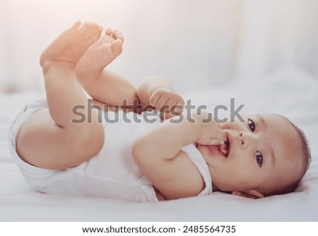 Image, Stock Photo Curious beautiful baby boy in blue body lying on playing mat, looking in the camera