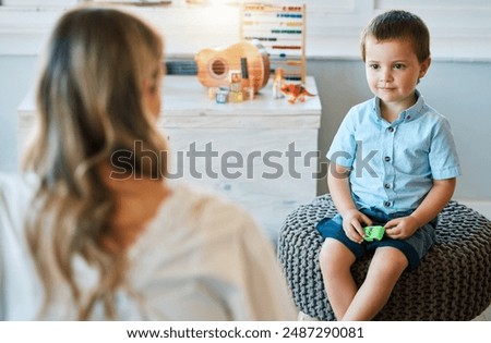 Similar – Image, Stock Photo Boy with Autism communicating with ipad while eating a homemade gluten free muffin; plastic animal toys nearby