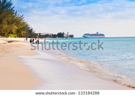 GRAND CAYMAN, CAYMAN ISLANDS - MAR.8:  Tourists enjoying Seven Mile Beach in Grand Cayman on Mar. 8, 2013.  The beach is a local tourist attraction, offering many luxury resorts and water sports.