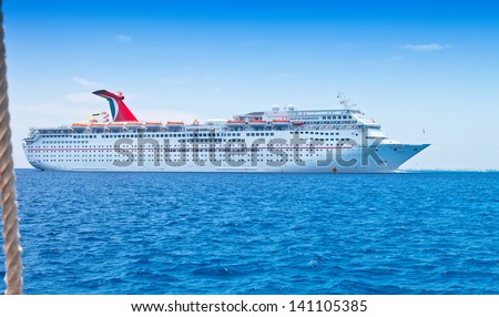 GRAND CAYMAN, CAYMAN ISLANDS - JULY 13:  Carnival Cruise Lines ship, the Inspiration, anchored off shore on July 13, 2011. It\'s one of the oldest Carnival ships, considered fine for short getaways.