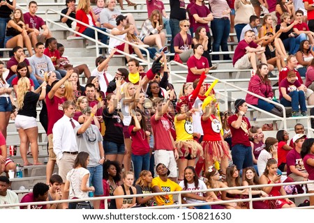 TALLAHASSEE, FL - OCT. 27:  College students cheering in the stands at a Florida State University football game in Tallahassee, Florida on October 27, 2012.