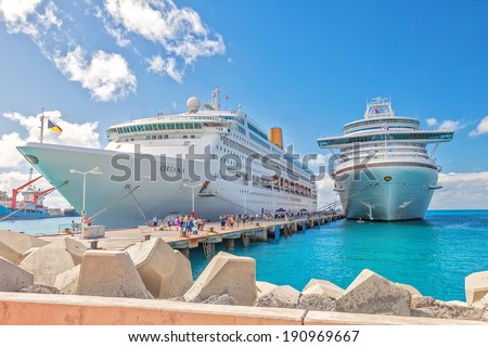 PHILIPSBURG, ST. MAARTEN - JAN. 16, 2013: Cruise ships docked at pier on the Dutch side of St. Maarten.  Passengers wanting to go to town are tendered to the smaller Hodge Pier in Philipsburg.