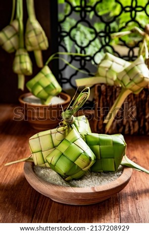 Close up view of Ketupat, an Indonesian traditional cuisine very popular during Hari Raya Idul Fitri served on a wooden table. This is made of the white rice, usually served with opor ayam on Ied day. Stok fotoğraf © 