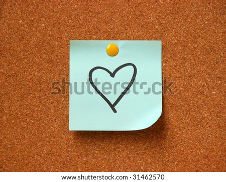note pad with heart drawing on cork board