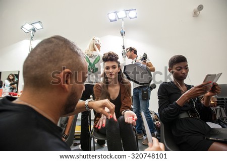 MILANO, SEPTEMBER 23, 2015: Staff working on the nails of a model at the backstage of Stella Jean during the presentation of spring-summer 15/16 collection at Milan Fashion Week 2015.