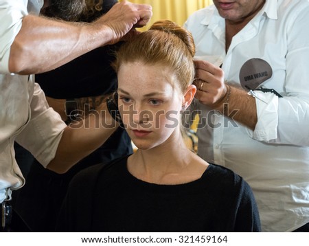 MILANO, ITALY - SEPTEMBER 25, 2015: A model gets her hair done ahead of the Uma Wang catwalk during the presentation of spring-summer collection at Milan Fashion Week 2015.