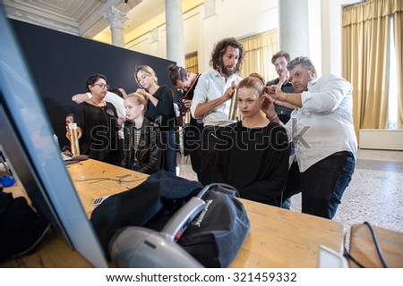 MILANO, ITALY - SEPTEMBER 25, 2015: A model gets her hair done ahead of the Uma Wang catwalk during the presentation of spring-summer collection 15/16 at Milan Fashion Week  2015.