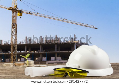 business Growing  file of safety helmet and architect plant on wood table with  construction