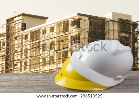 safety helmet and architect plant on wood table with  construction,vintage color