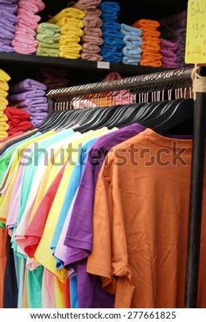 Shop shirts colorful fabric hanging on a rack.