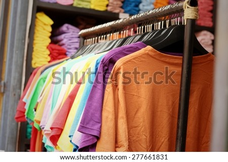 Shop shirts colorful fabric hanging on a rack.