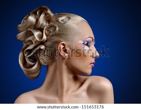 face of young woman with coiffure makeup on blue background