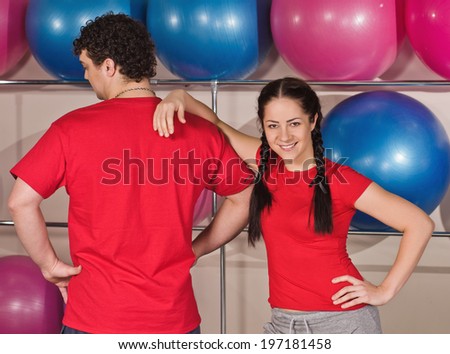 Portrait of happy young couple with standing together in gym. with balls background