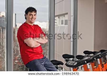 Portrait of young man on bike in health club.