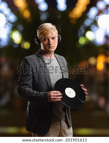 DJ man with vinyl on nightlife lights background