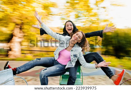 girls friends laughing and outdoor on the carousel