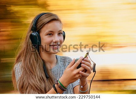Happy girl having fun with music headphones. background with natural motion blur