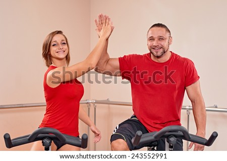 Happy couple portrait indoor biking in a fitness club