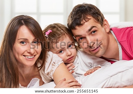 A young family with little daughter to bed in the bedroom