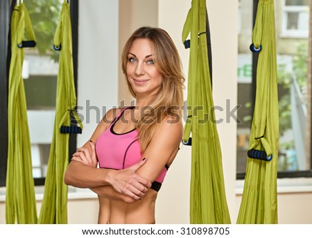 Young woman posing about anti-gravity aerial yoga green hammock indoor