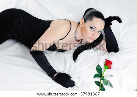 luxurious lying  brunette on white bed clothes