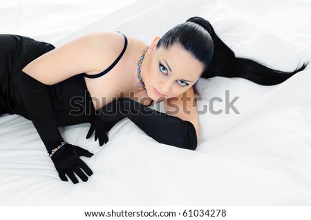 luxurious lying  brunette on white bed clothes