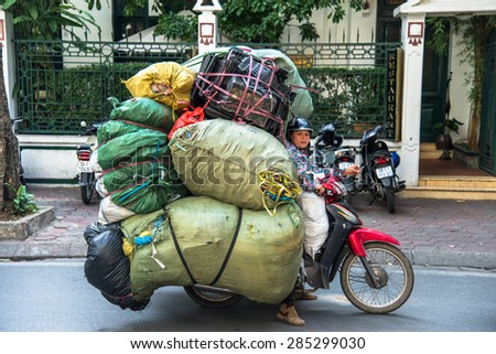HANOI, VIETNAM, NOV 17, 2013: Unidentified woman drives overloaded motorcycle on the street of Hanoi on November 17, 2013