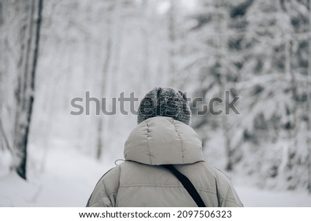 Photo of Winter snow walk woman walking away in snowy forest on woods trail outdoor lifestyle active people. Outside leisure.