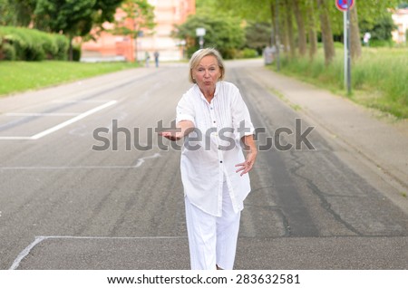 Portrait of a Middle Aged Blond Woman in All White Outfit, Walking at the Street Alone in friendly Facial Expression.