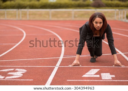 Young Afro-American Businesswoman Looking at the Camera While in a Start Position on Race Track.