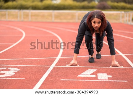 Young Afro-American Businesswoman Looking at the Camera While in a Start Position on Race Track.