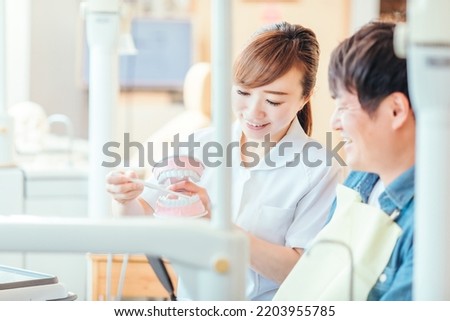 Asian female dental hygienist and patient teaching tooth brushing Foto d'archivio © 