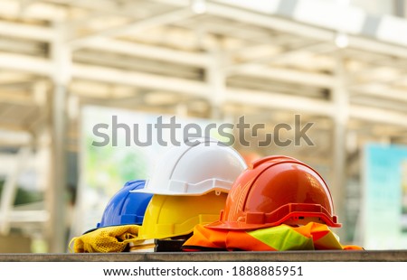 Close up Blue, yellow, white and red hard safety helmet hats for safety project of workman as engineering or project worker place on concrete floor city outdoor.