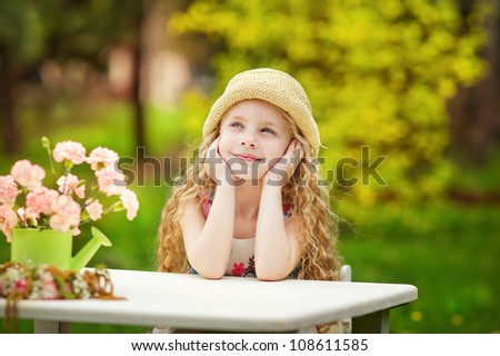 Little pretty girl dreaming in the green garden