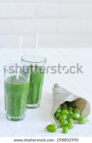 Healthy diet concept, still life with two glasses and freshly squeezed juice and gooseberries