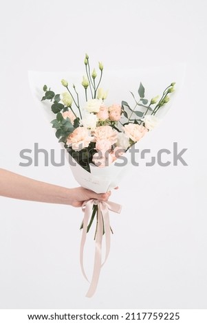 Image, Stock Photo Hand holding bouquet of pink and white flowerson wooden table at flower shop. Floristics and selling flowers small business. Pink fresh spring floral background with copy space on light gray background.