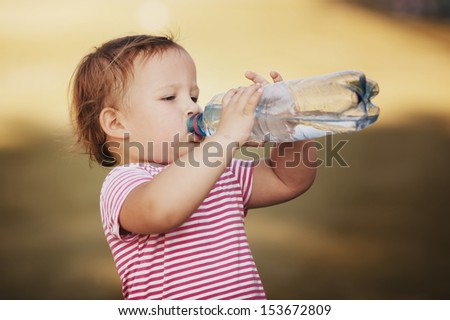 little girl with bottle of mineral water