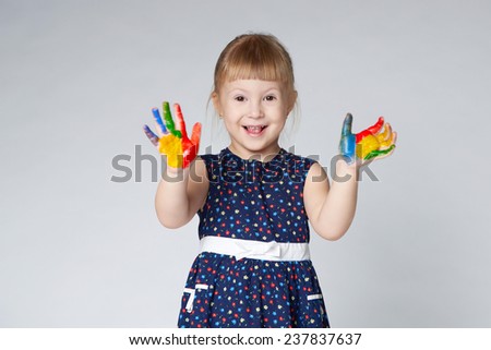 little girl with hands in paint on white