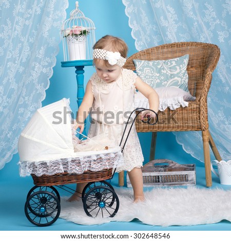 cute little girl playing with dolls and stroller