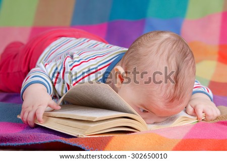 cute baby reading book on colorful background