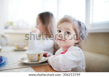 cute little girl drinks tea in the morning