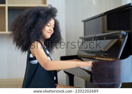 Similar – Image, Stock Photo Smiling child playing piano in cozy room in daylight