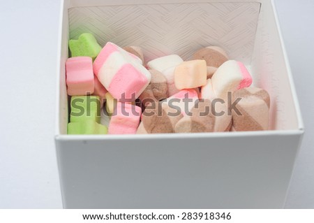 MULTI-SHAPED SMALL MARSHMALLOWS IN A BOX IN WHITE BACKGROUND