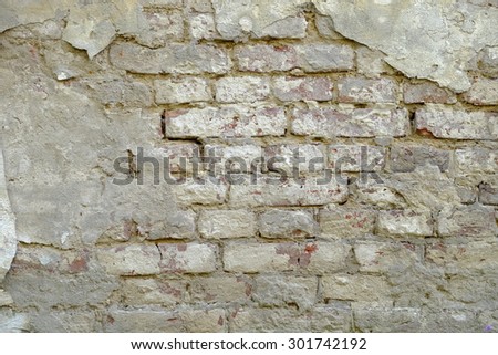 Beaten, old, gray, dirty brick wall, with pieces of putty on it, background texture, close up