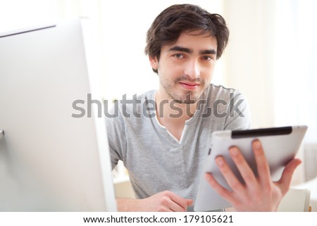 View of a  young relaxed men at the office using tablet